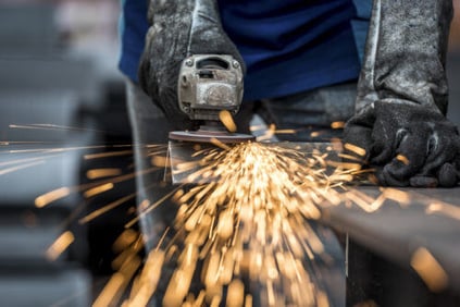 A saw cutting a metal component with sparks